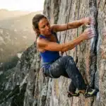 Femme escaladant une paroi rocheuse en montagne