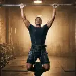 Homme musclé effectuant une traction à la barre avec poids