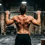 Homme musclé effectuant une traction à la barre en salle de sport