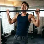 Homme musclé effectuant des tractions à la barre fixe