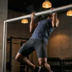 Homme effectuant des tractions à la barre horizontale en salle de sport