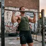 Homme musclé effectuant une traction à la barre en extérieur