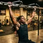 Homme musclé en traction à la barre dans une salle de sport