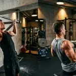 Deux hommes musclés s'entraînent dans une salle de gym moderne