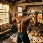 Homme musclé effectuant tractions à la barre en gym
