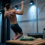 Homme musclé effectuant des tractions à la barre horizontale