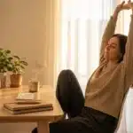 Femme s'étire à son bureau près de plantes vertes