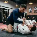 Deux hommes s'entraînent au jiu-jitsu sur un tapis de gym