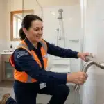 Femme en uniforme montrant une barre d'appui de salle bain